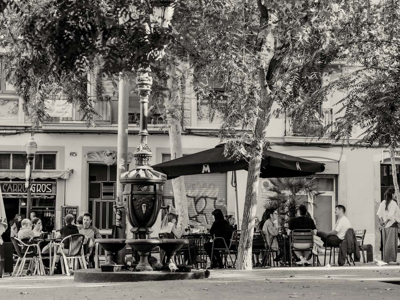 Nachbarn sitzen draußen auf der Terrasse der Plaça del Sortidor in Poble-sec